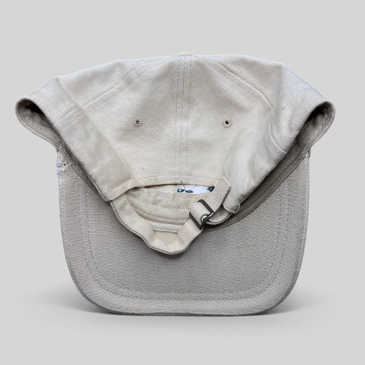 Raree Finds vintage off-white cotton canvas strapback hat with metal buckle closure, back view.