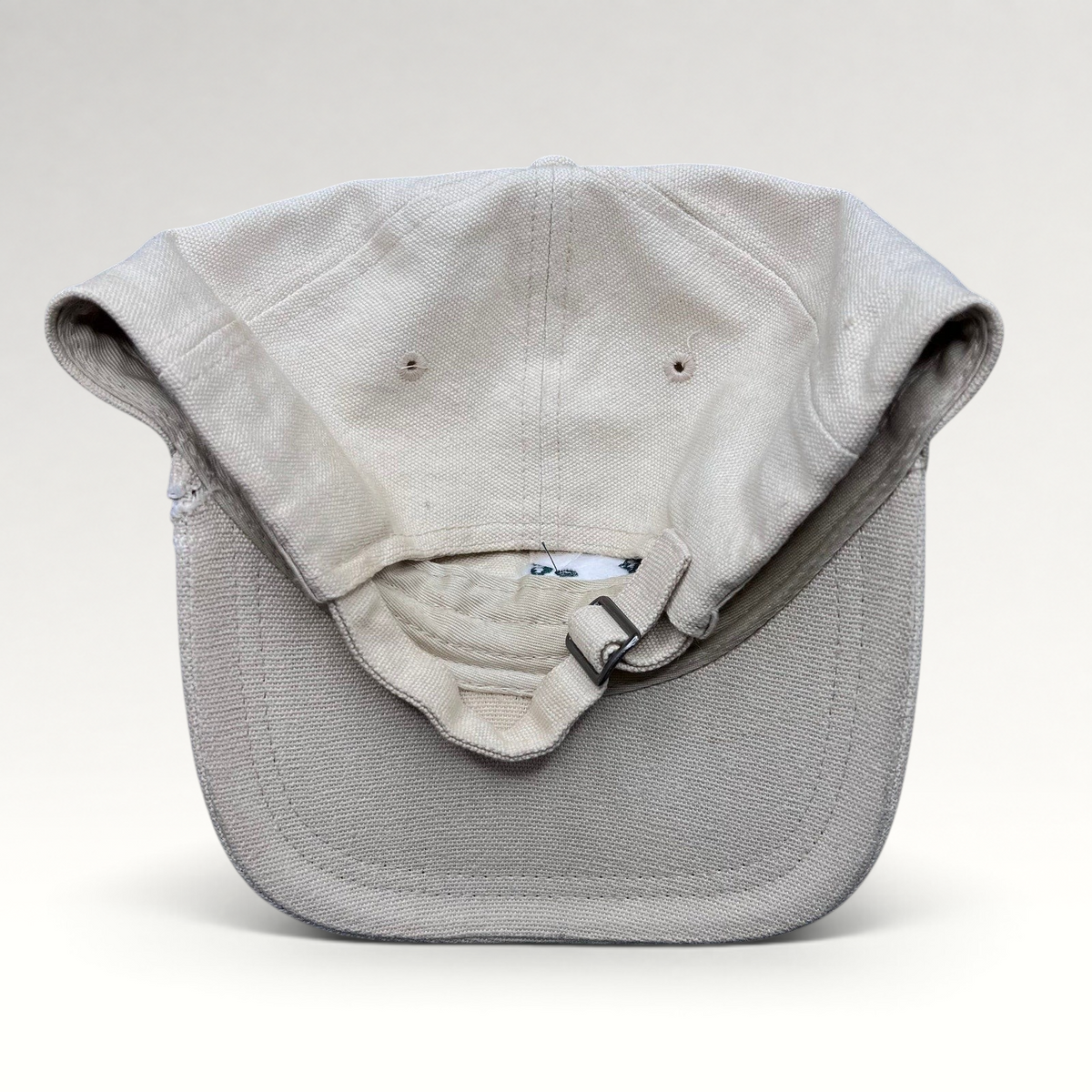 Raree Finds vintage off-white cotton canvas strapback hat with metal buckle closure, back view.