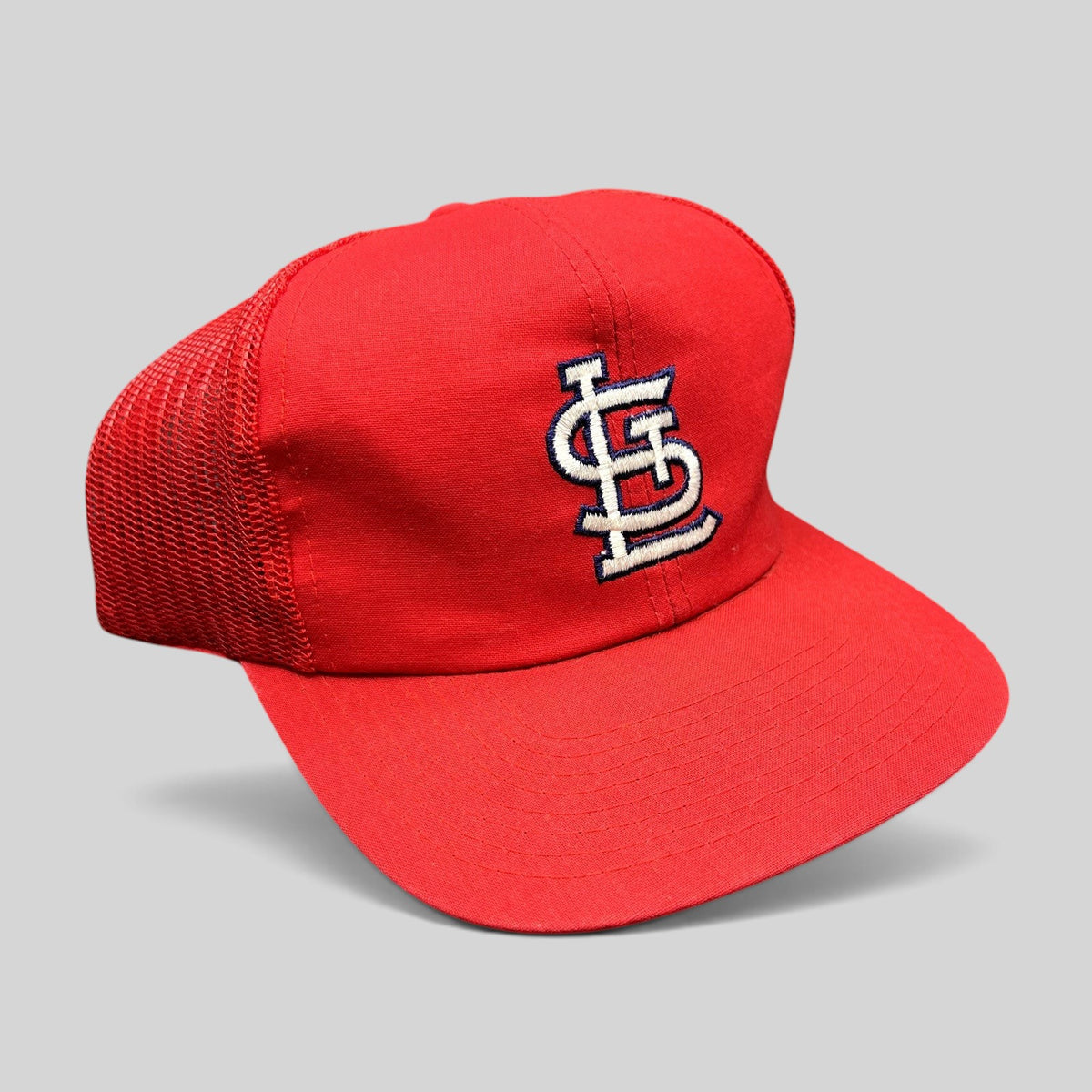 Raree Finds vintage St. Louis Cardinals red mesh snapback trucker hat with embroidered STL logo and green undervisor.