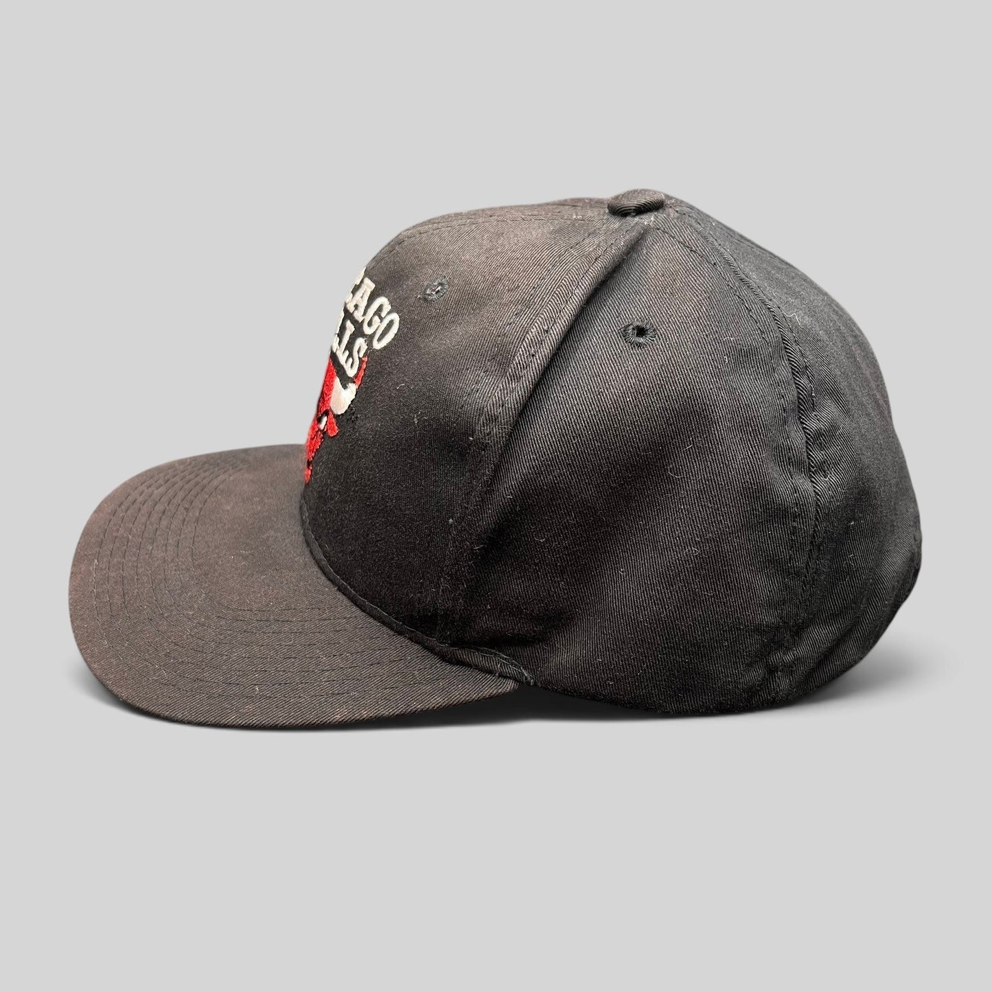 Raree Finds vintage 90s Chicago Bulls AJD snapback hat in black with red embroidered logo and green undervisor.