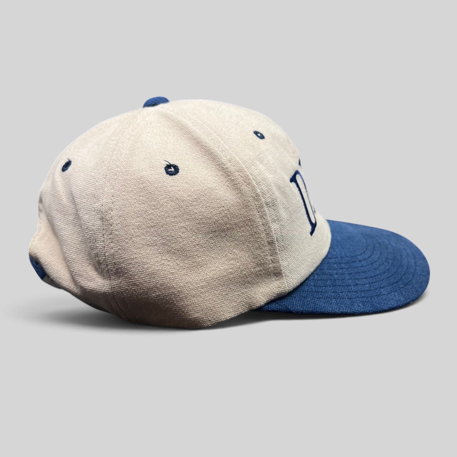 Raree Finds vintage Yupoong DEA strapback hat with a tan cotton crown and navy blue brim, side profile view.