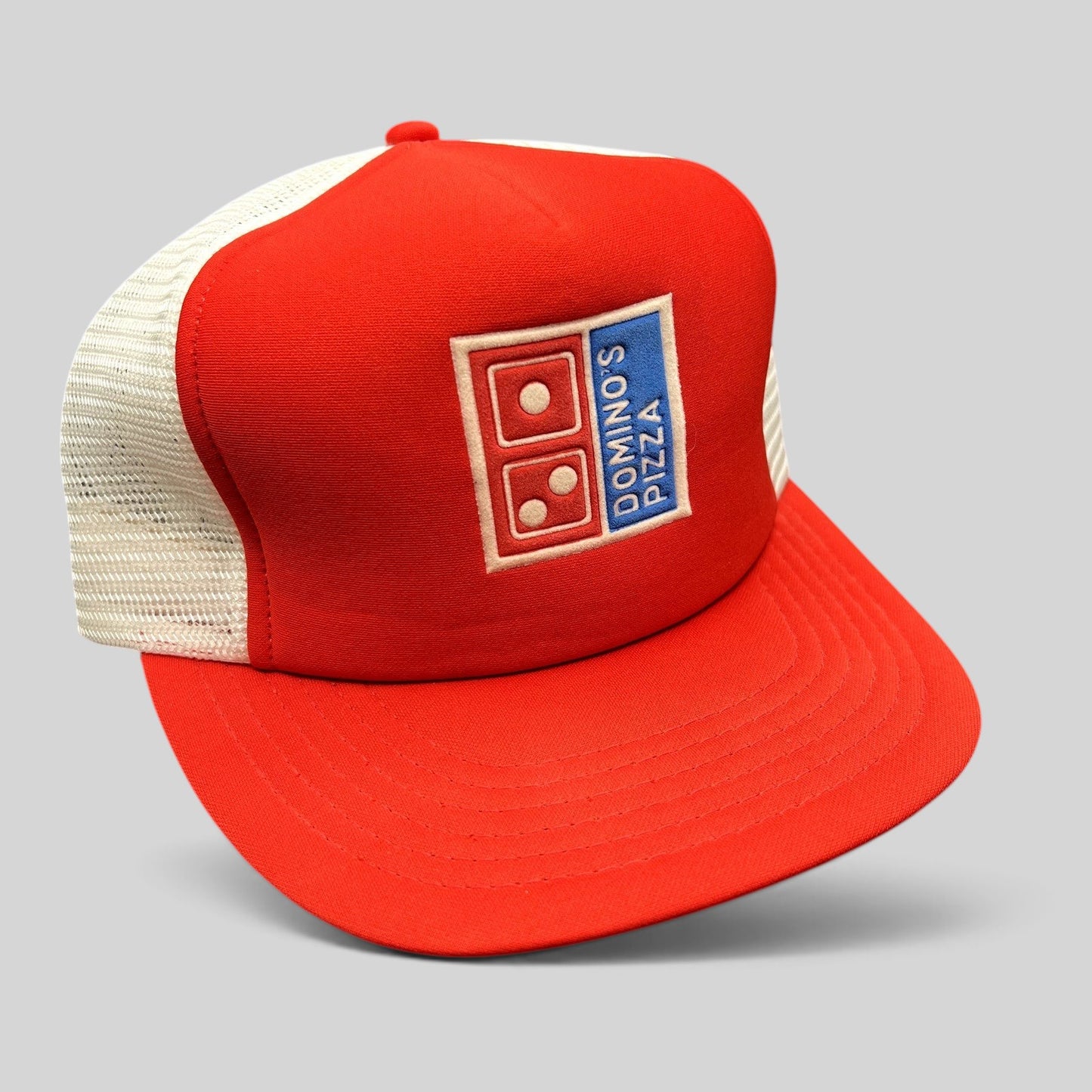 Raree Finds vintage 1980s Domino’s Pizza trucker hat with red foam front, white mesh back, and embroidered logo.