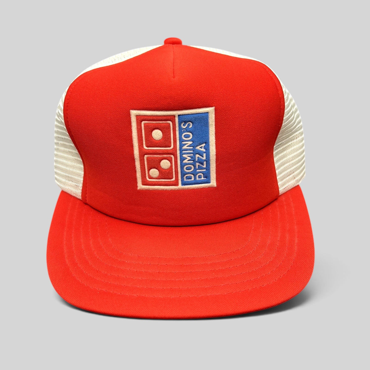 Raree Finds vintage 1980s Domino’s Pizza trucker hat with red foam front, white mesh back, and embroidered logo.