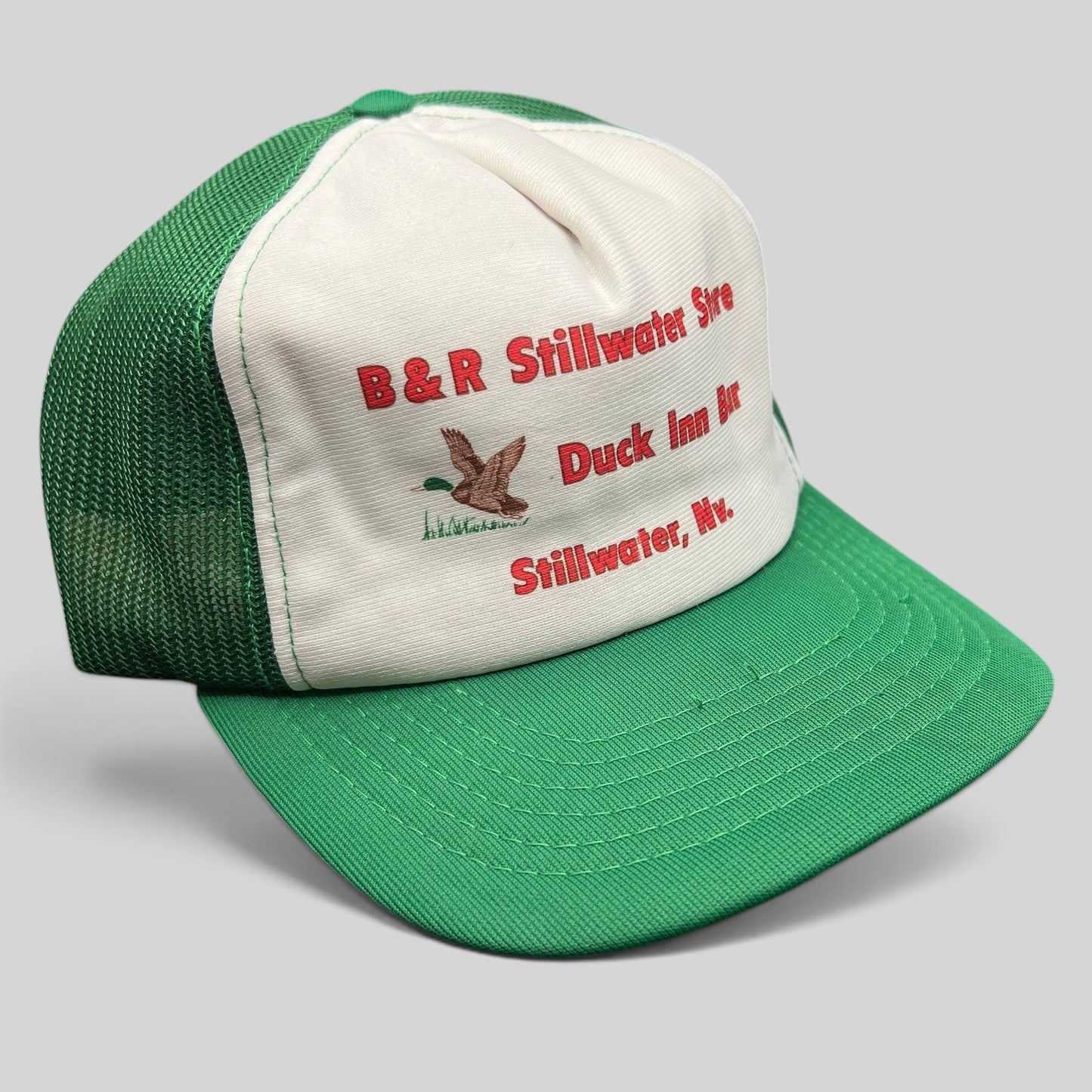 Raree Finds vintage 1980s trucker hat with white foam front, green mesh back, and Duck Inn Bar embroidery