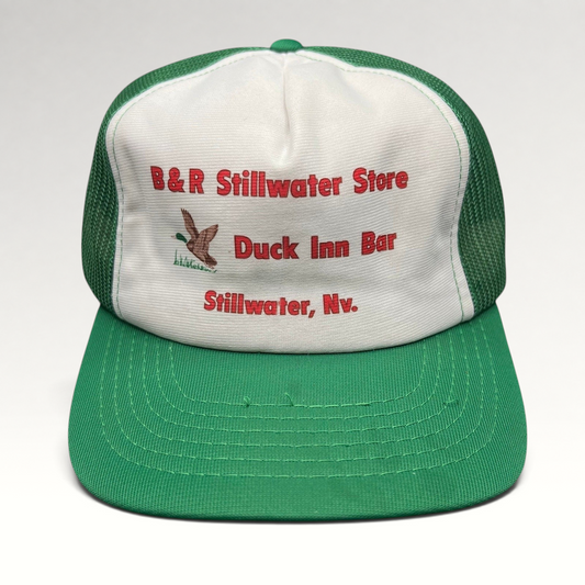 Raree Finds vintage 1980s trucker hat with white foam front, green mesh back, and B&R Stillwater Duck Inn embroidery.