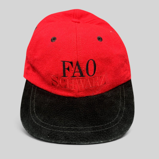 Raree Finds vintage FAO Schwarz youth strapback hat in red wool with a black brim and embroidered logo.