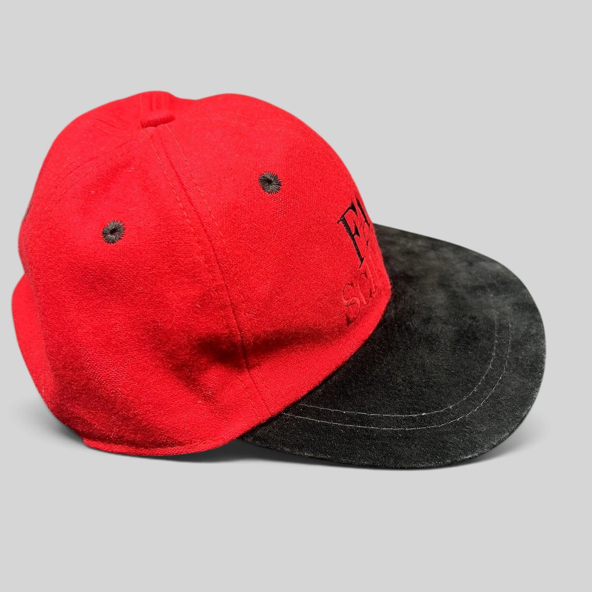 Raree Finds vintage FAO Schwarz youth strapback hat in red wool with a black brim and embroidered logo.