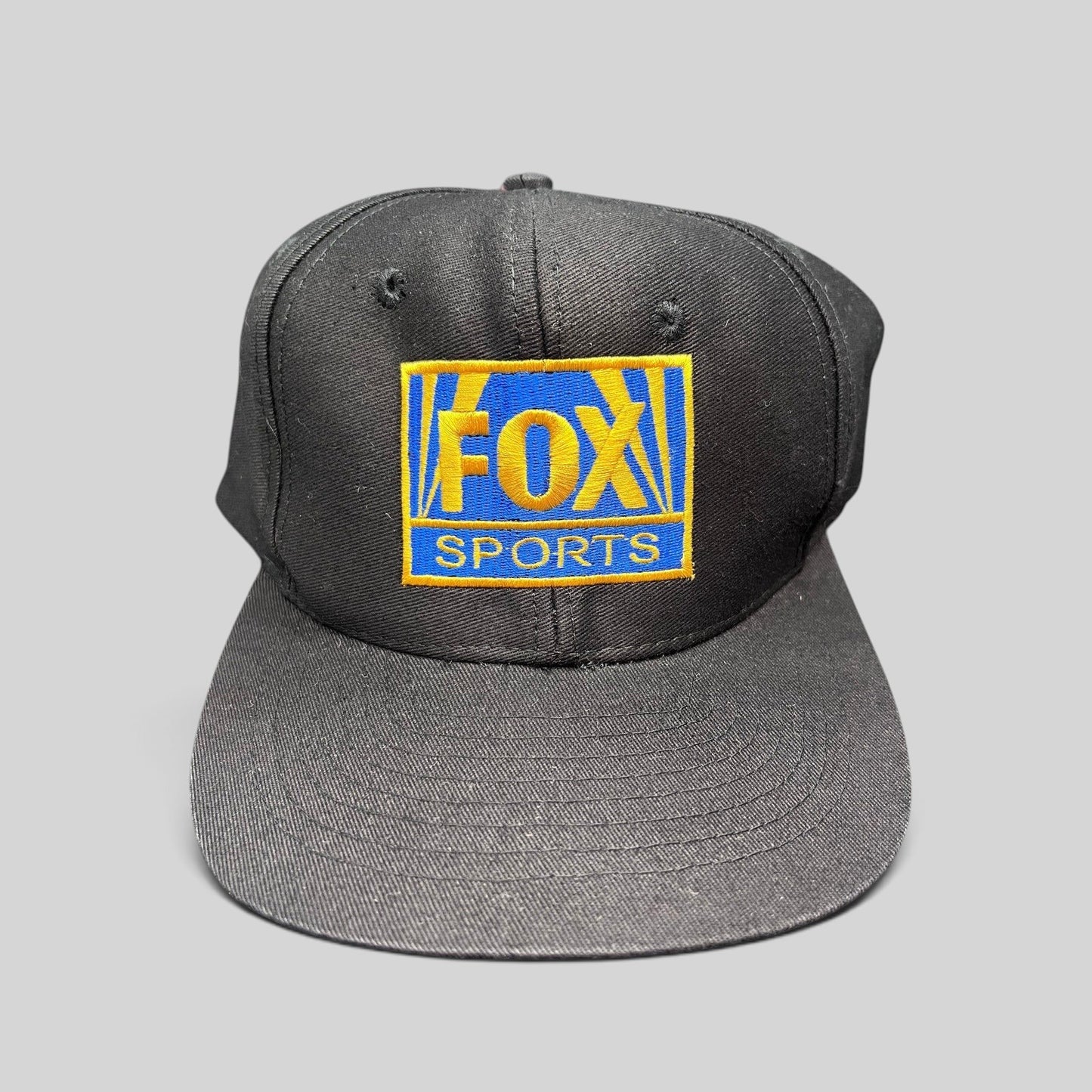 Raree Finds vintage 90s FOX Sports black cotton snapback hat with gold and royal blue embroidered logo