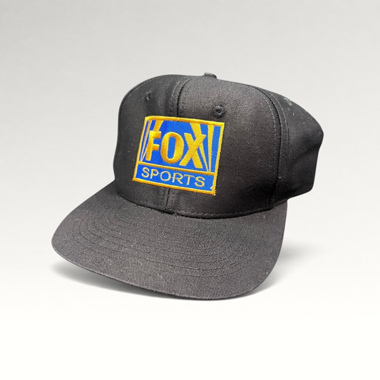 Raree Finds vintage 90s black cotton snapback hat featuring an embroidered gold and royal blue FOX Sports logo.