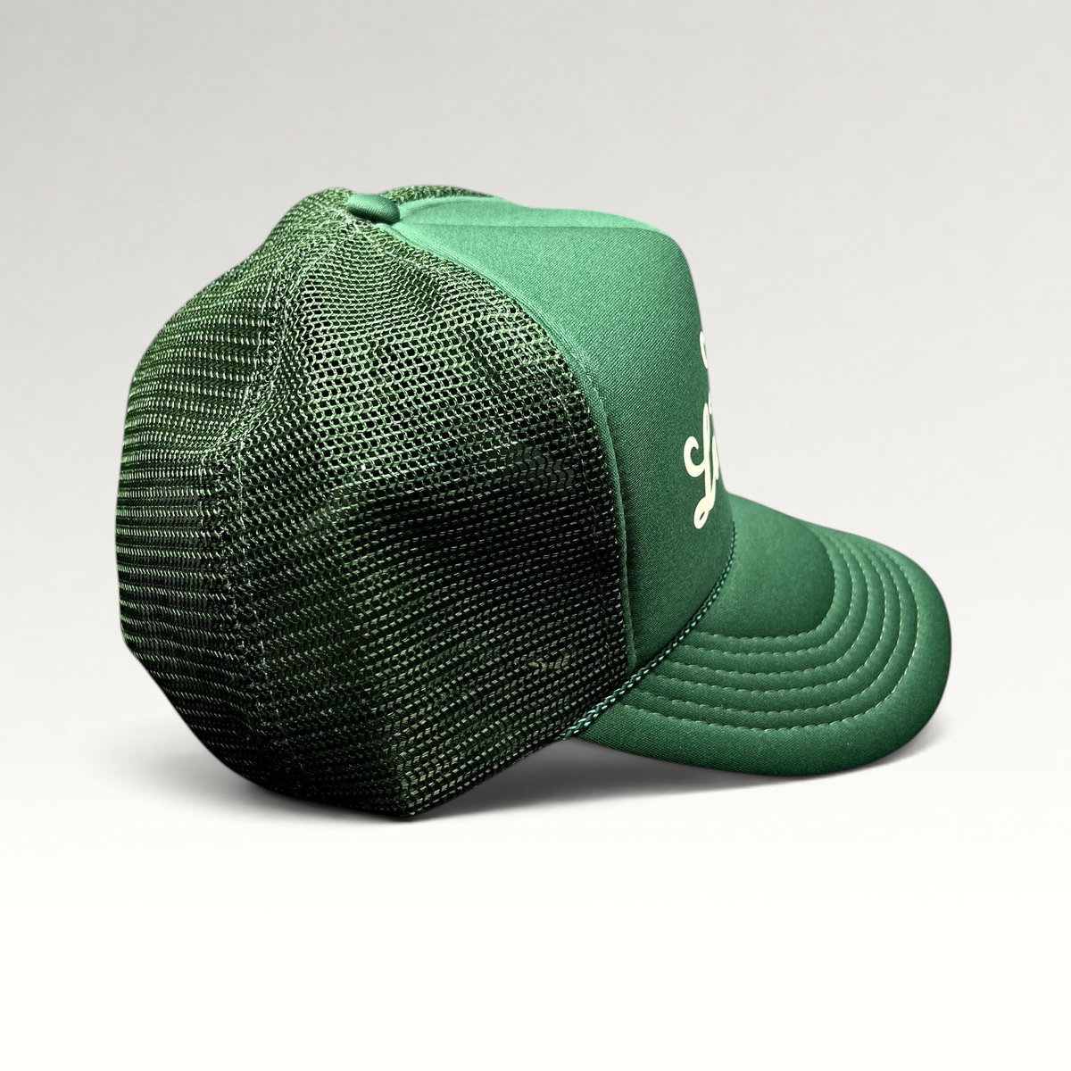 Raree Finds vintage green mesh trucker hat with foam front, white script logo, and braided rope detail on the brim.
