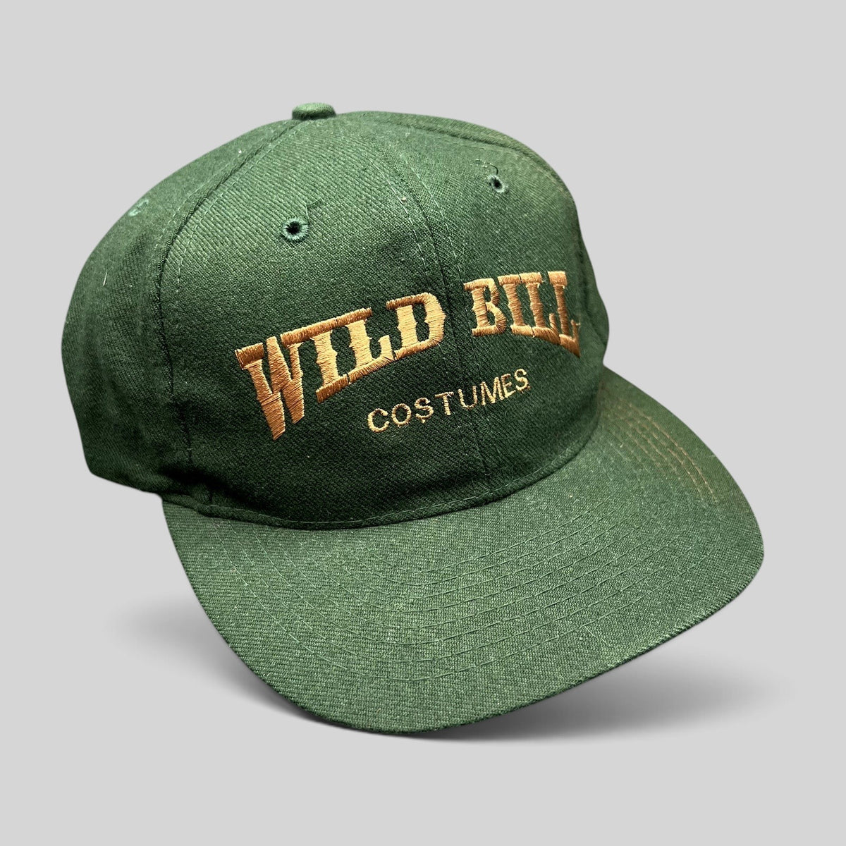 Raree Finds vintage dark green Otto Cap snapback hat with brown Wild Bill Costumes embroidery and flat brim