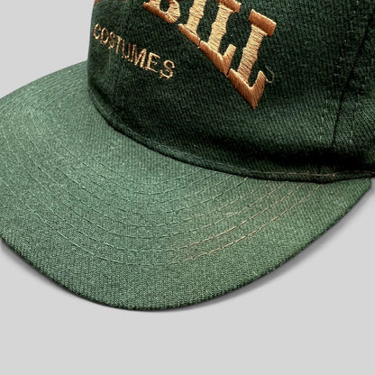 Raree Finds vintage dark green Otto Cap snapback hat with brown Wild Bill Costumes embroidery on the structured crown.