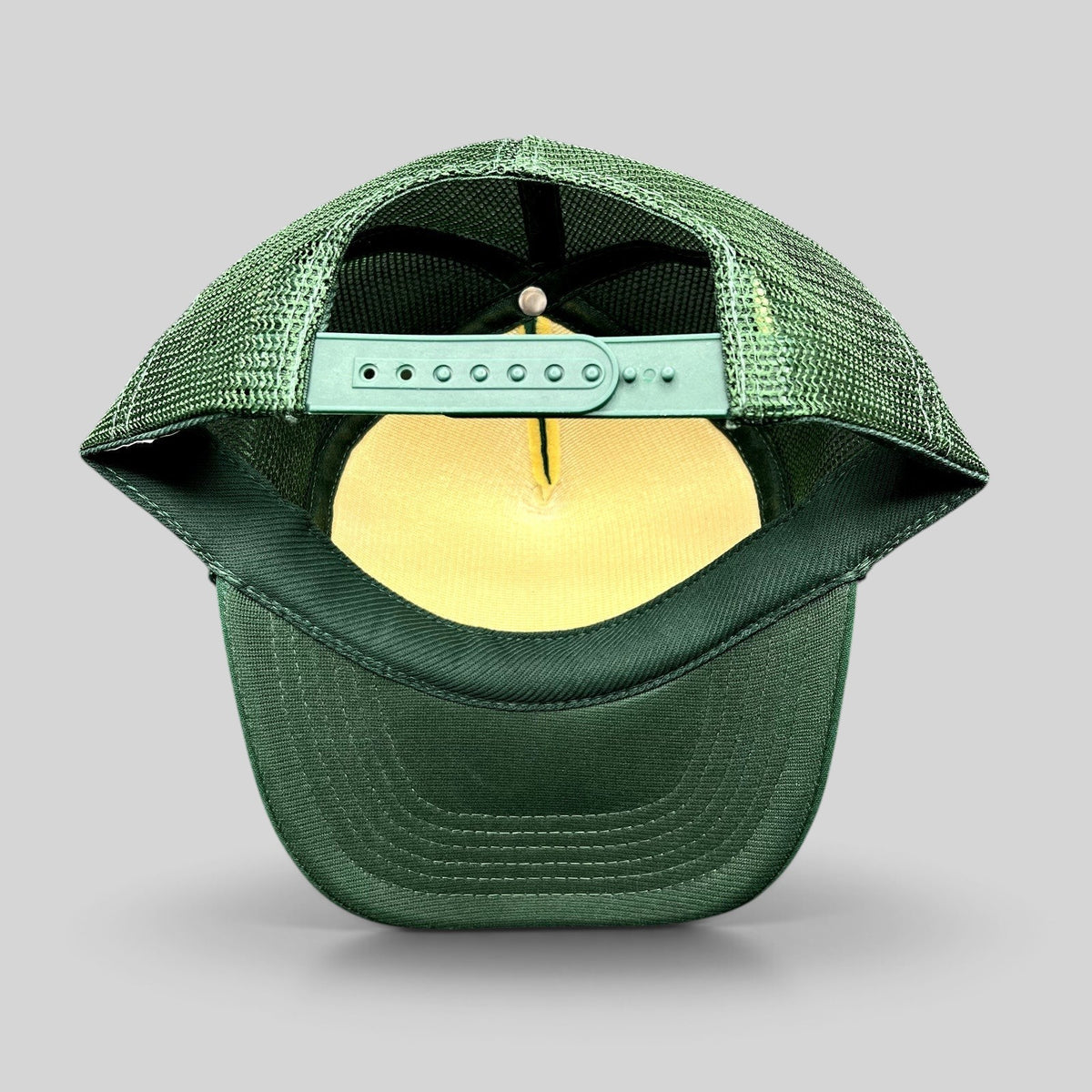 Raree Finds vintage green mesh trucker hat showing the adjustable snapback closure and interior foam lining