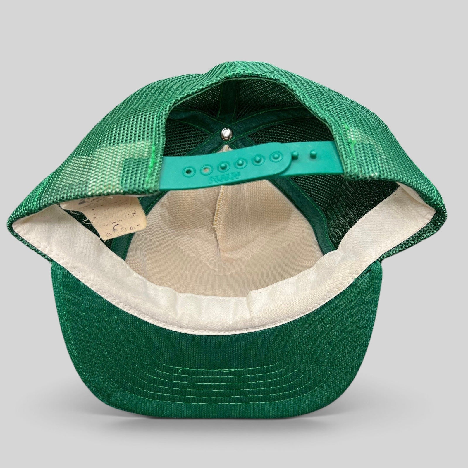Raree Finds vintage green mesh trucker hat interior showing snapback closure and Young An manufacturer tag