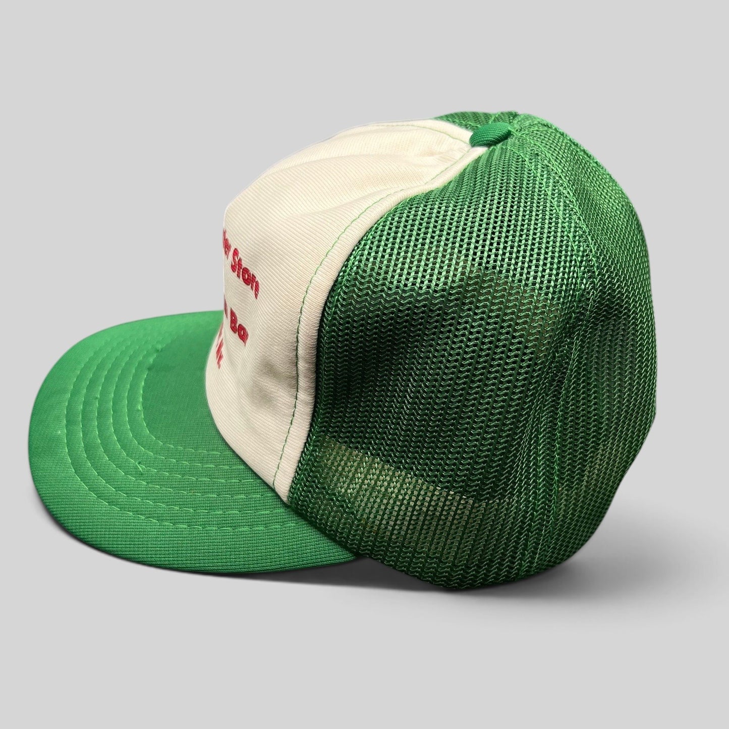 Raree Finds vintage 1980s trucker hat with green mesh back, white foam front, and red Duck Inn Bar embroidery