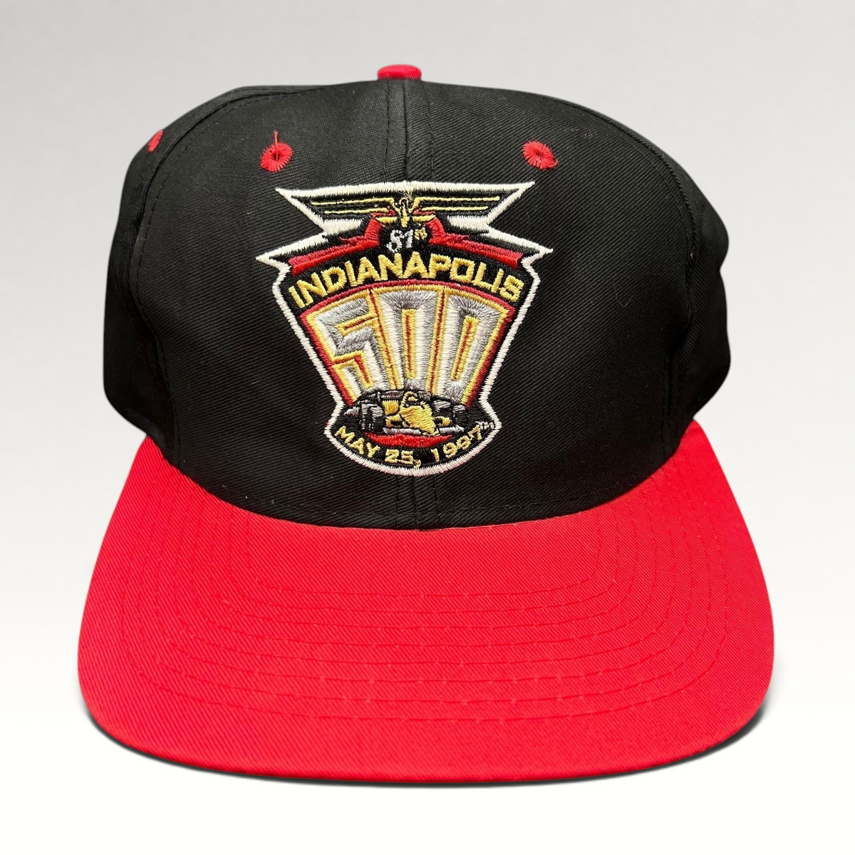 Raree Finds vintage 1997 Indianapolis 500 snapback hat with black crown, red brim, and embroidered racing logo.