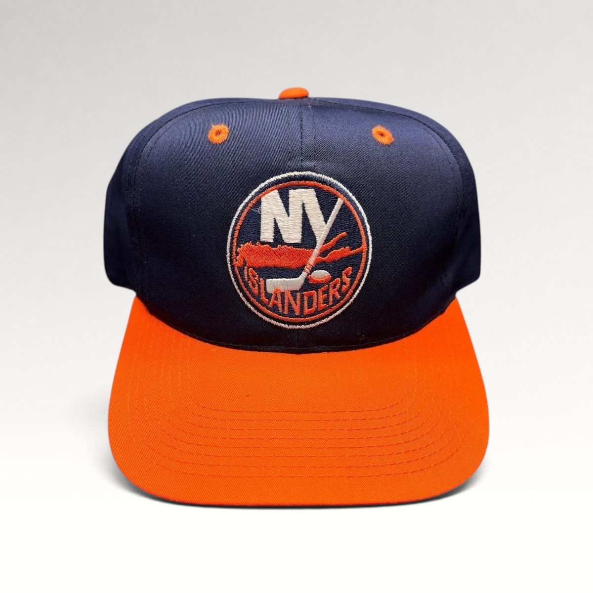 Raree Finds vintage 1990s New York Islanders snapback hat in navy and orange with embroidered team logo.