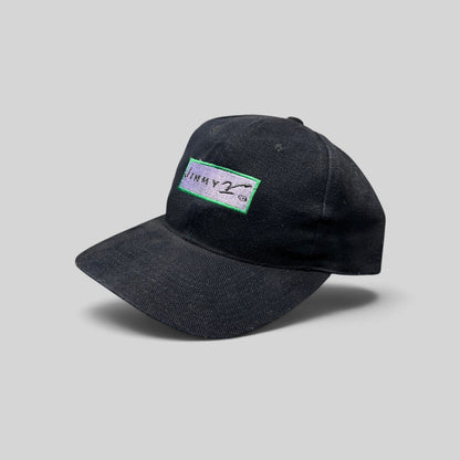 Raree Finds vintage black cotton Jimmy V snapback hat with embroidered logo patch on a dark background