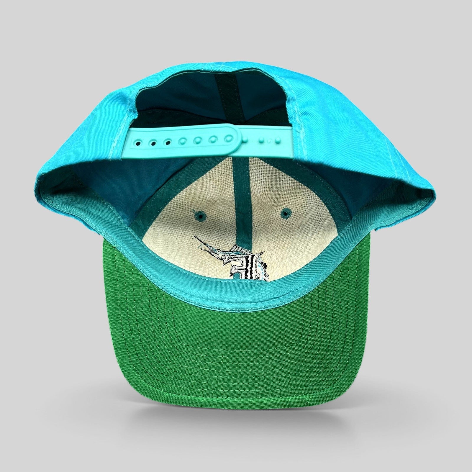 Raree Finds vintage Florida Marlins snapback hat showing the green undervisor and adjustable teal plastic strap
