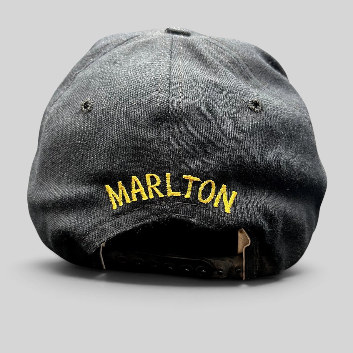 Raree Finds vintage black New Era snapback hat with gold Marlton embroidery on the back and adjustable plastic strap.