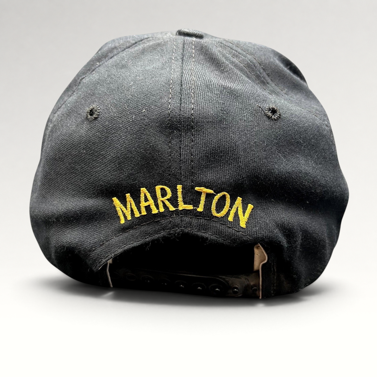 Raree Finds vintage black New Era snapback hat with gold Marlton embroidery on the back and adjustable plastic strap.