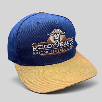 Raree Finds vintage navy and tan snapback hat featuring an embroidered Melody Ranch Motion Picture Studio longhorn logo