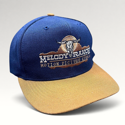 Raree Finds vintage navy and tan snapback hat featuring an embroidered Melody Ranch Motion Picture Studio longhorn logo