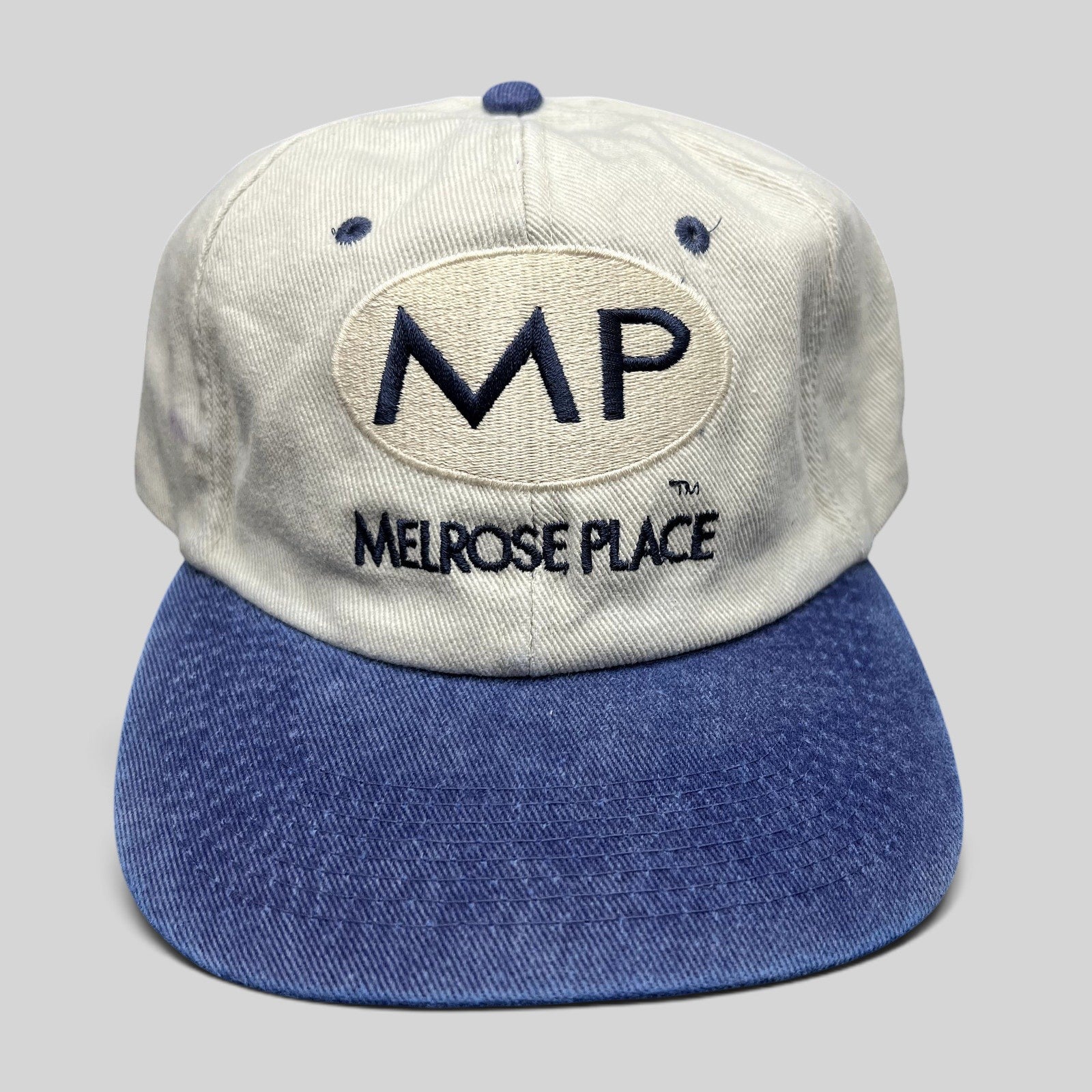 Raree Finds vintage Melrose Place FOX TV show strapback hat with cream crown, blue brim, and navy embroidered logo.
