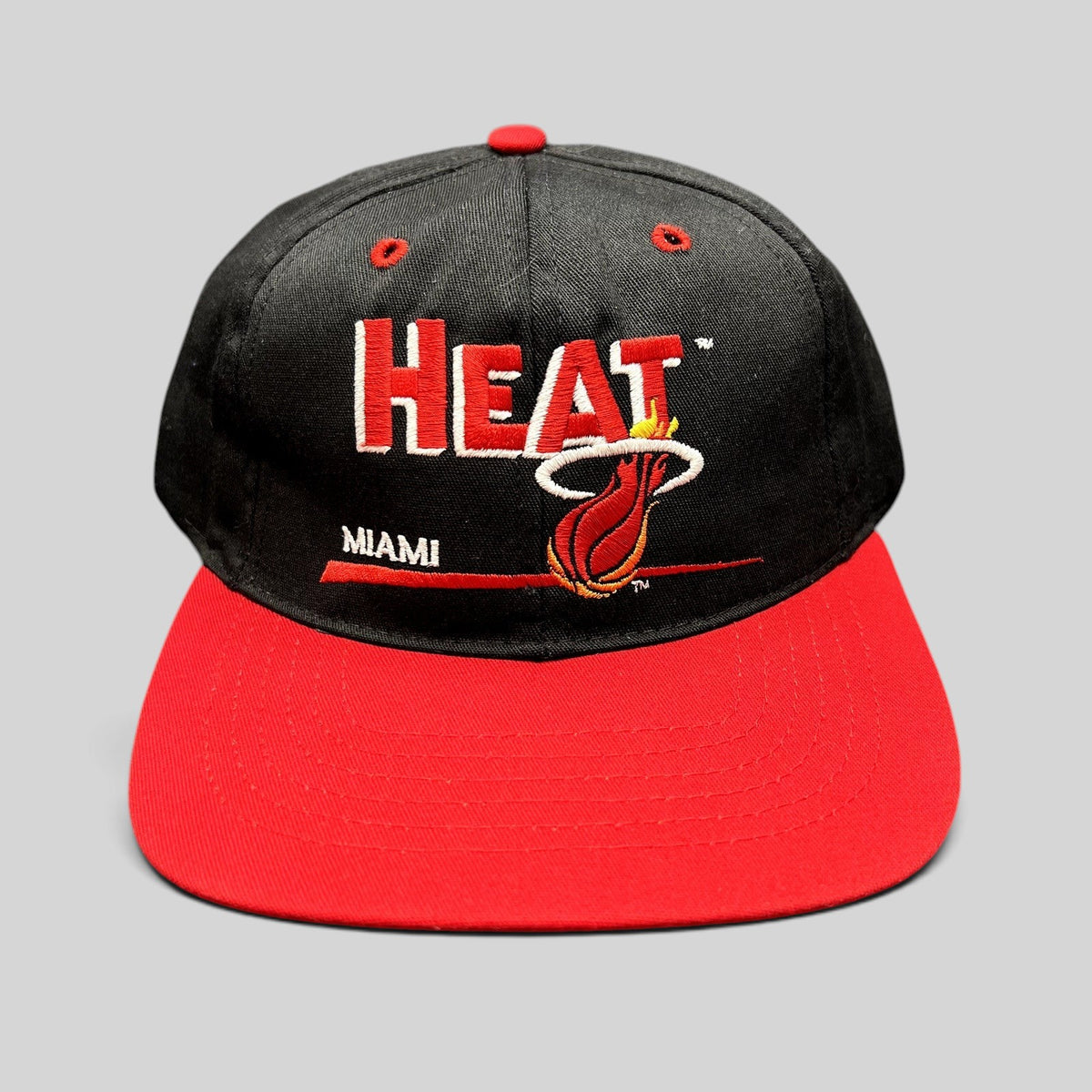Raree Finds vintage 1990s Miami Heat snapback hat with black crown, red brim, and embroidered flaming basketball logo.