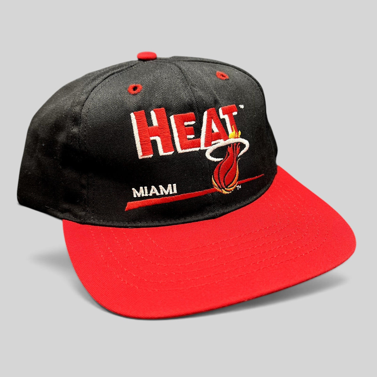 Raree Finds vintage 1990s Miami Heat snapback hat with black crown, red brim, and embroidered flaming basketball logo.
