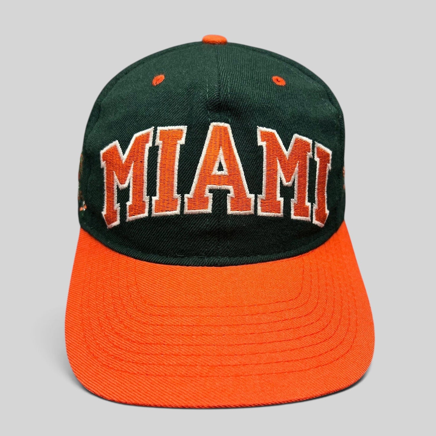 Raree Finds vintage Miami Hurricanes fitted hat with green crown, orange brim, and arched MIAMI embroidery.