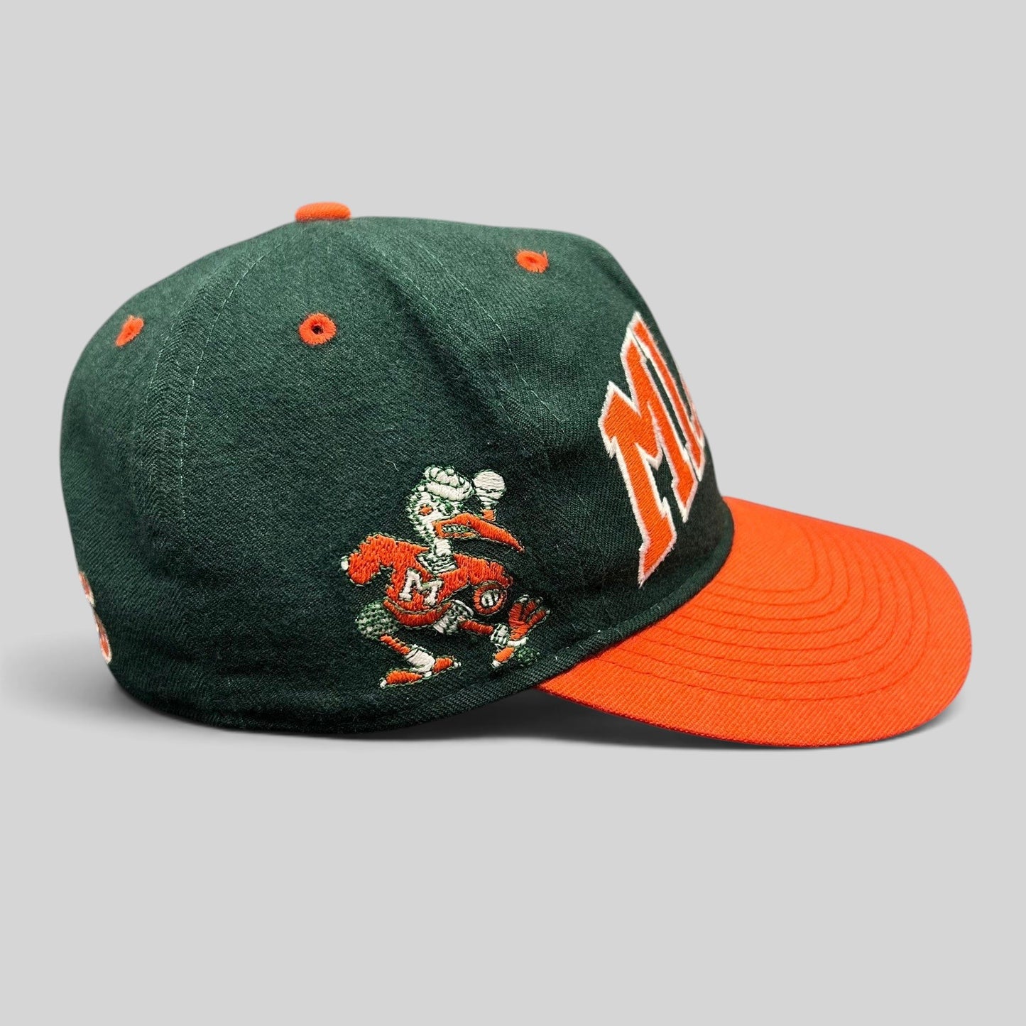 Raree Finds vintage Miami Hurricanes fitted hat with green wool crown, orange brim, and embroidered team mascot.