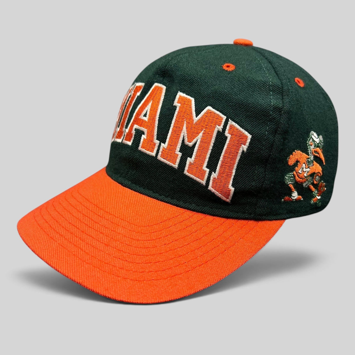 Raree Finds vintage Miami Hurricanes fitted hat with green crown, orange brim, and embroidered team logo.