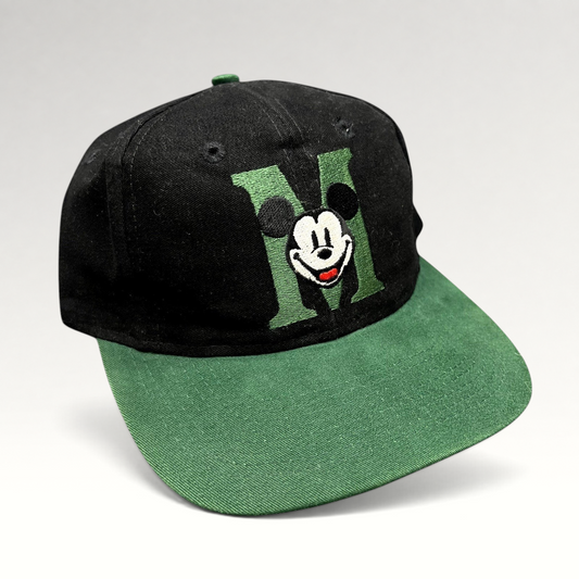 Raree Finds vintage 90s Disney Store black and green snapback hat with embroidered Mickey Mouse M logo on flat bill