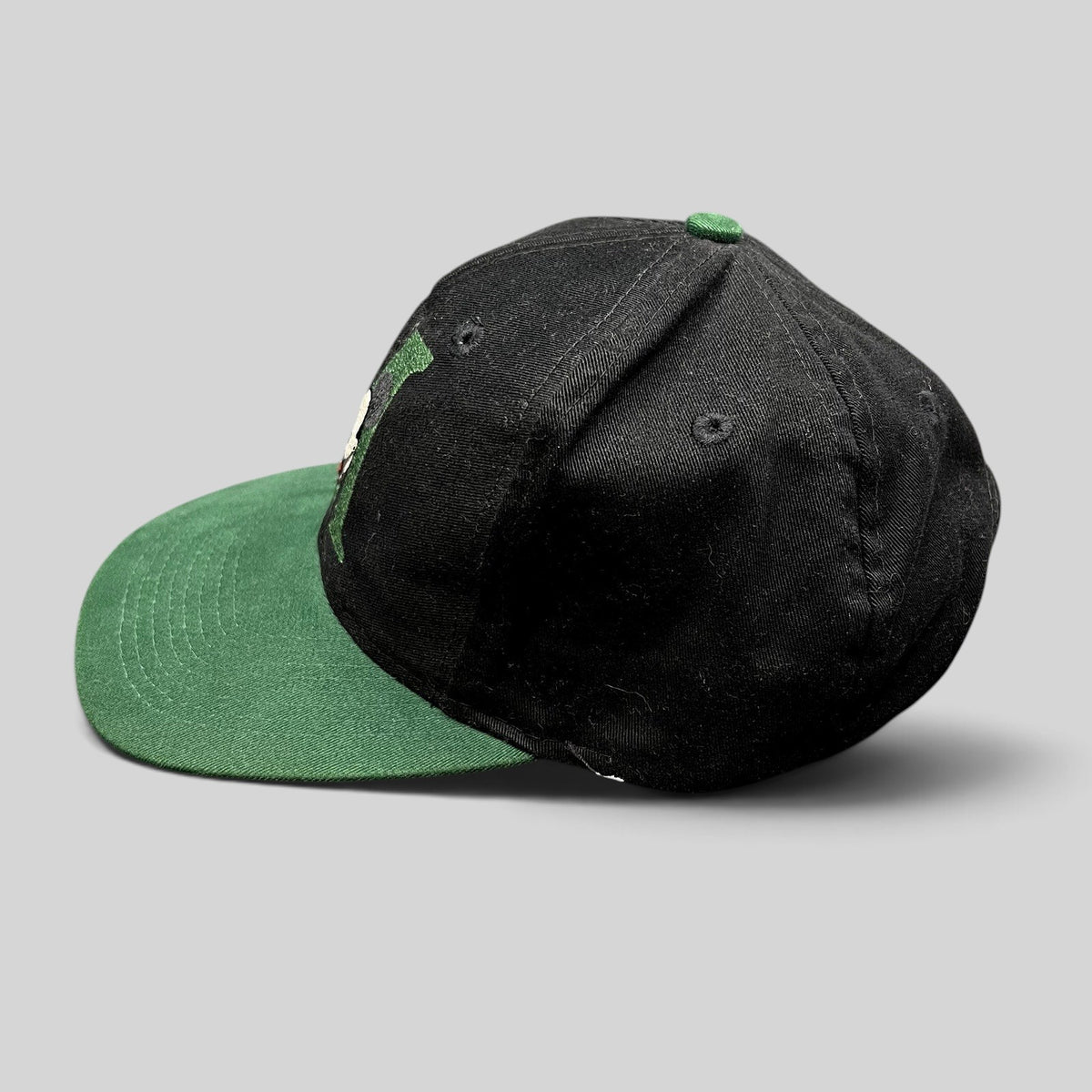 Raree Finds vintage 90s Disney Store Mickey Mouse snapback hat with black crown, green brim, and embroidered M logo.