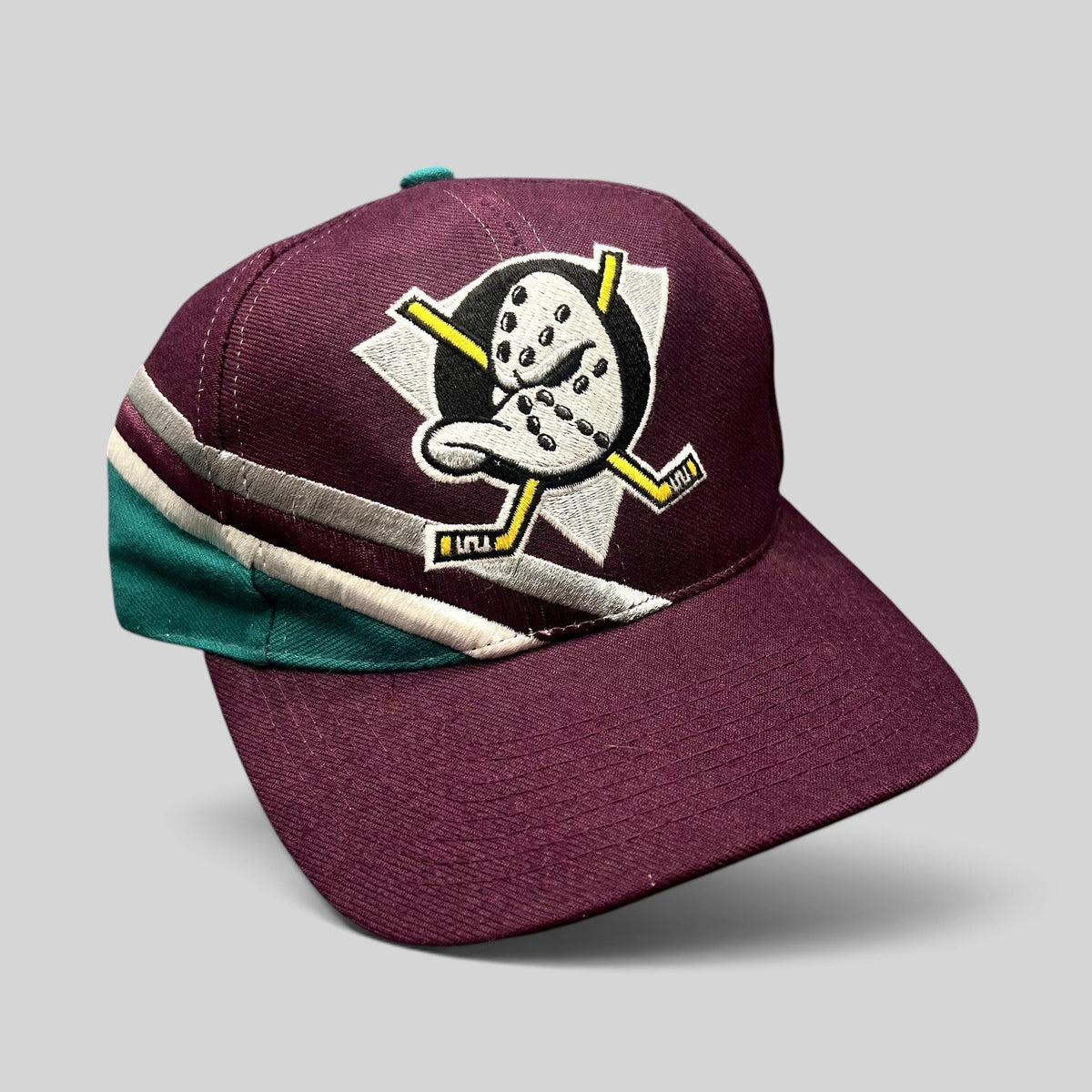 Raree Finds vintage Anaheim Mighty Ducks Apex One snapback hat in maroon with teal, silver, and white wave detail.