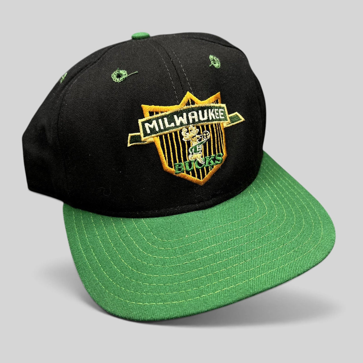Raree Finds vintage Milwaukee Bucks NBA snapback hat with embroidered shield logo, black crown, and green brim.