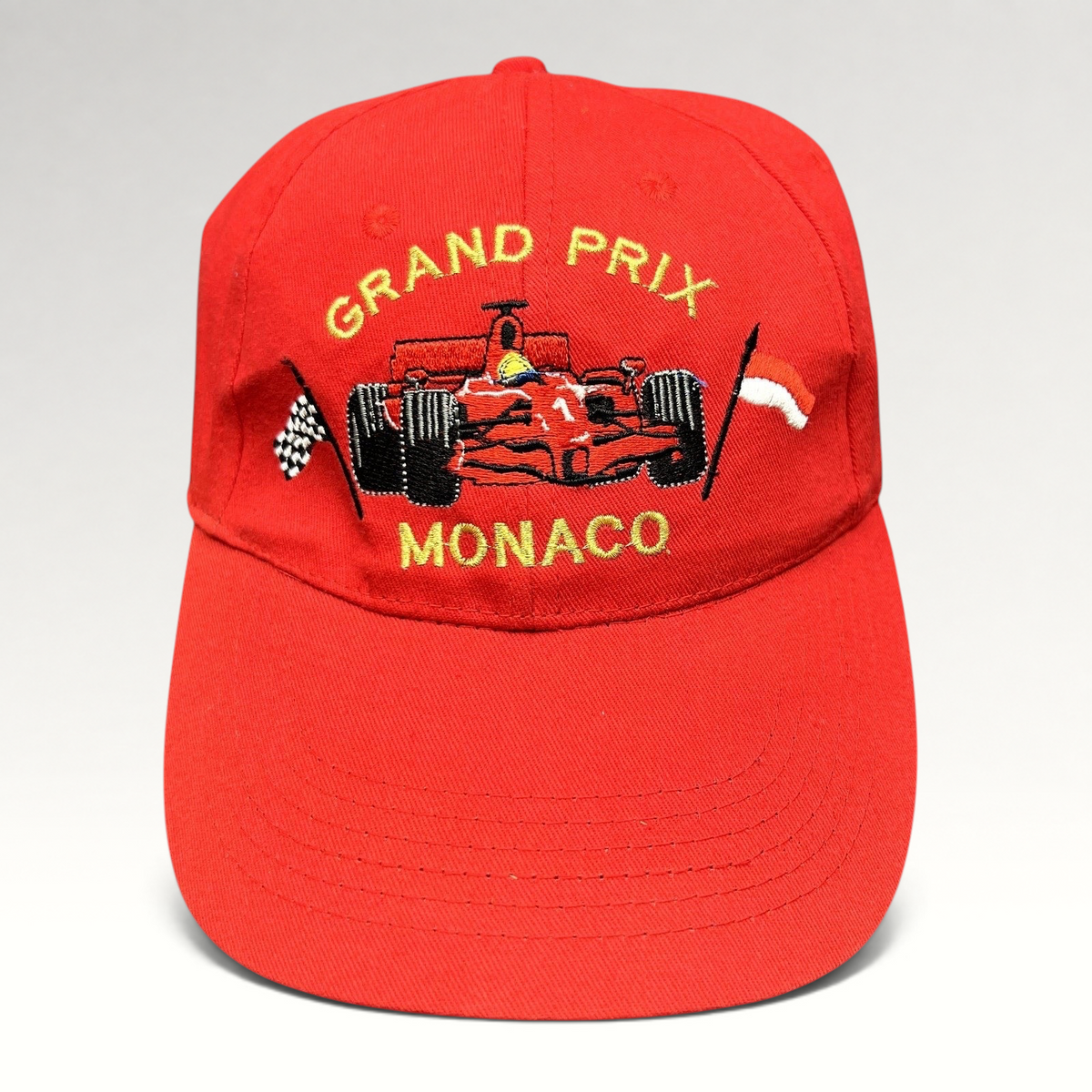 Raree Finds vintage red cotton Monaco Grand Prix racing hat with embroidered Formula 1 car and checkered flag detail.