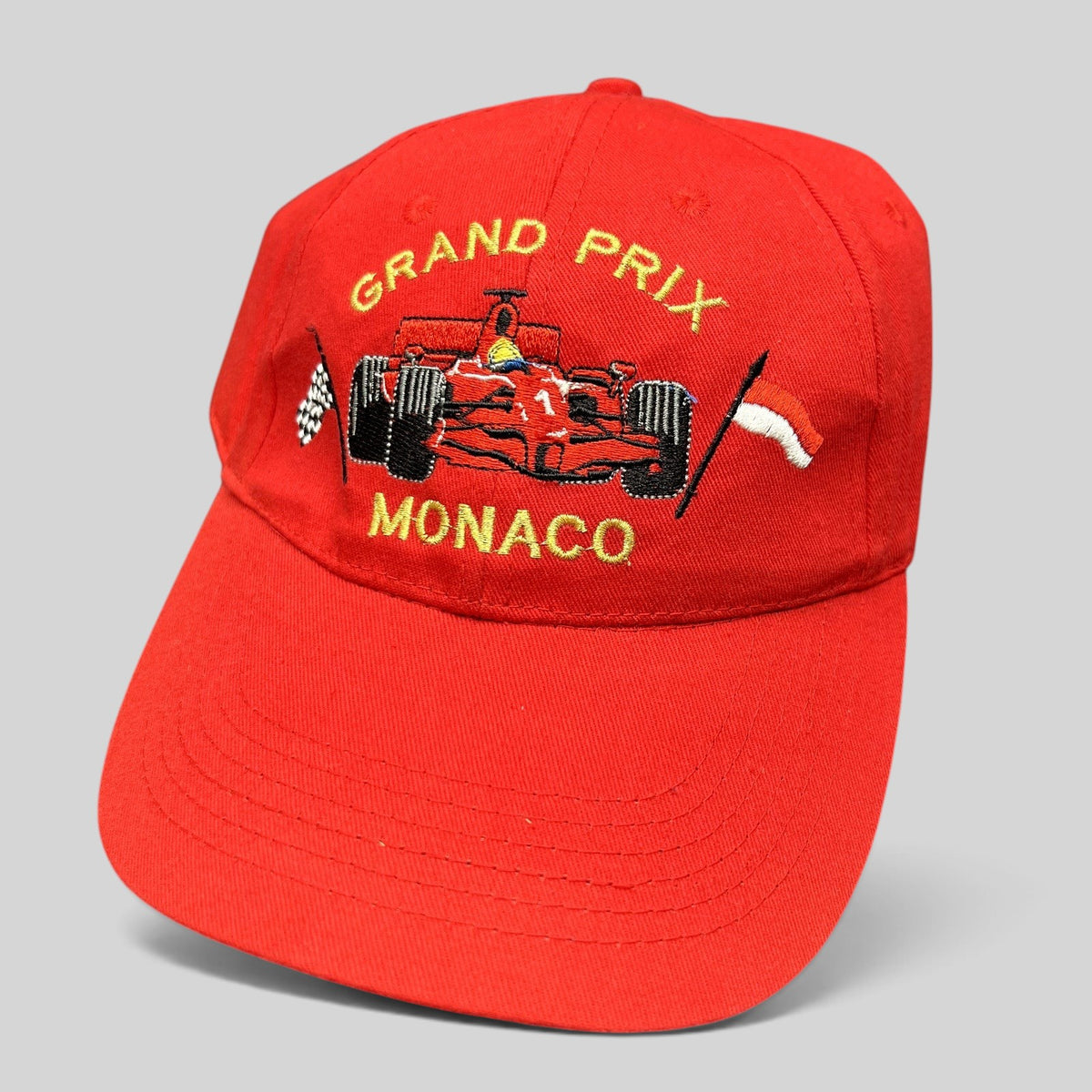 Raree Finds vintage red Monaco Grand Prix strapback hat with embroidered Formula 1 race car and checkered flag detail.