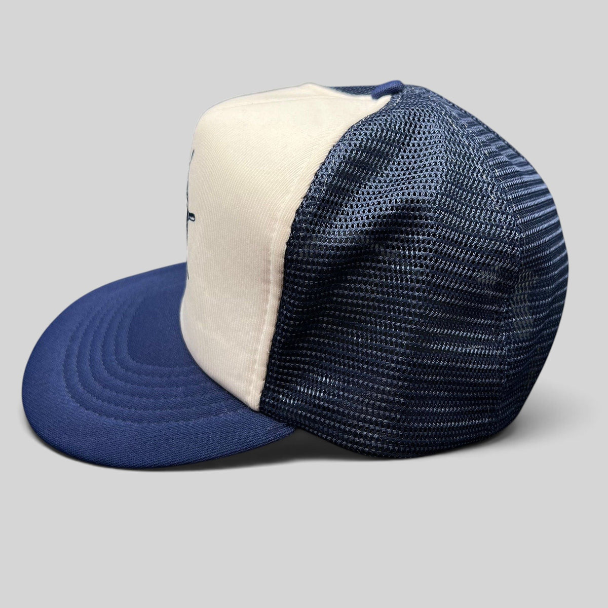 Raree Finds vintage Sunbelt trucker hat with white foam front, navy mesh back, and nautical ship wheel graphic.