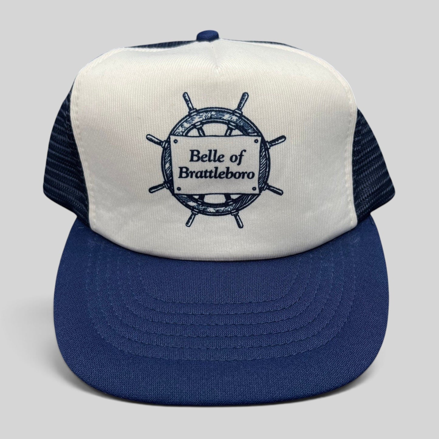 Raree Finds vintage Sunbelt trucker hat in white and navy with a nautical ship wheel Belle of Brattleboro graphic.