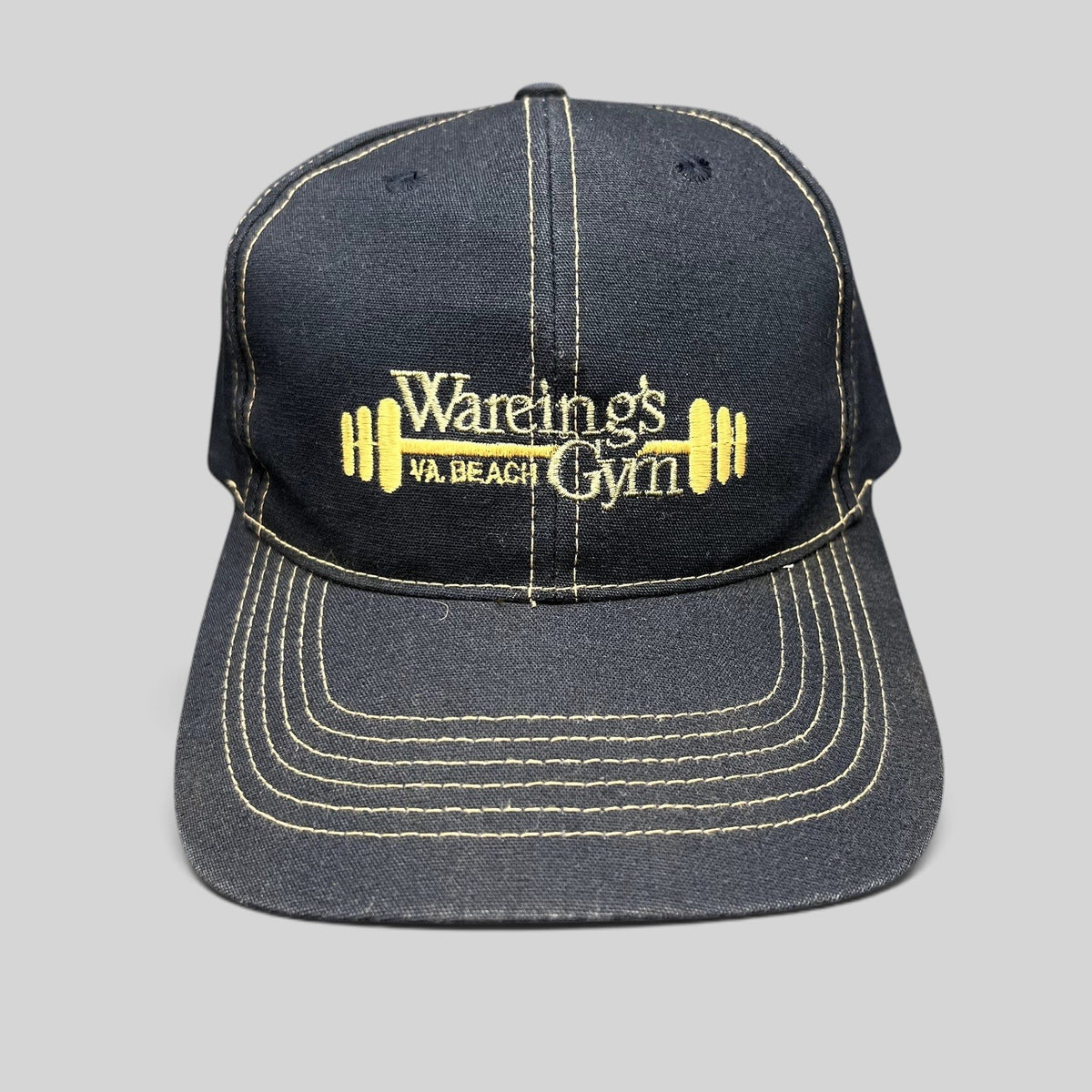 Raree Finds vintage navy blue Wareing’s Gym snapback hat with gold embroidered barbell logo and contrast stitching