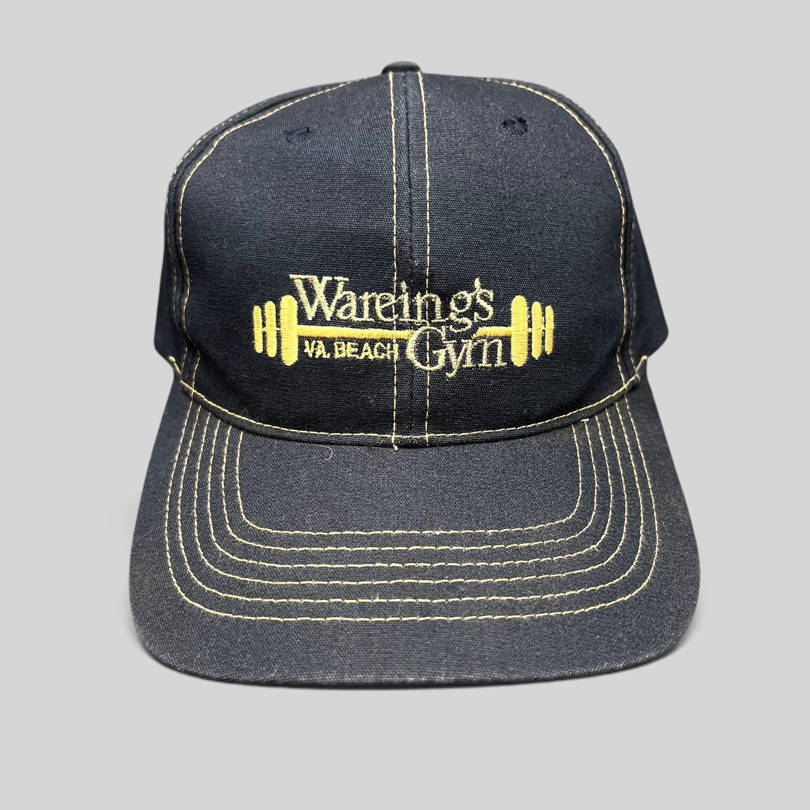 Raree Finds vintage navy blue Wareing’s Gym snapback hat with gold embroidered barbell logo and contrast stitching