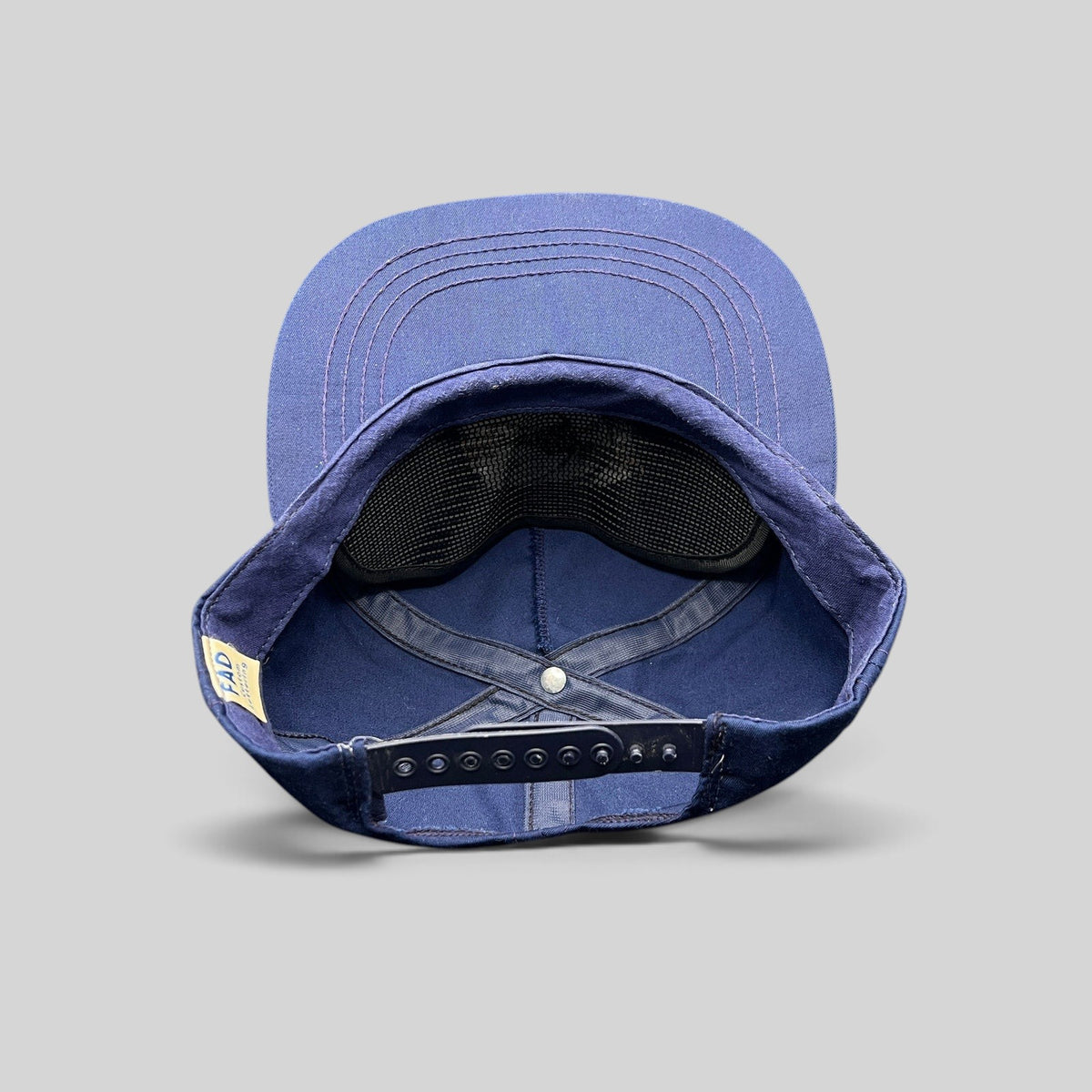 Raree Finds vintage navy blue cotton snapback hat showing the interior construction and FAD Custom Lettering tag