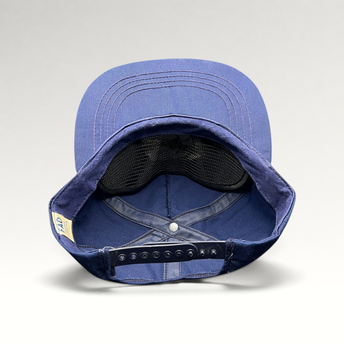 Raree Finds vintage navy blue cotton snapback hat showing the interior construction and FAD Custom Lettering tag