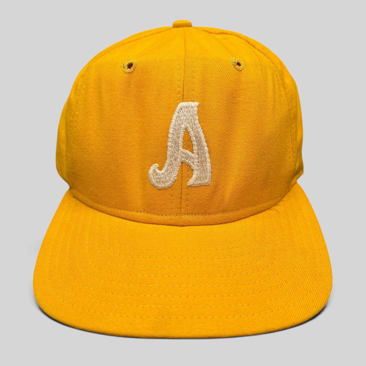 Raree Finds vintage New Era Pro Model A snapback hat in gold with embroidered white letter and green undervisor