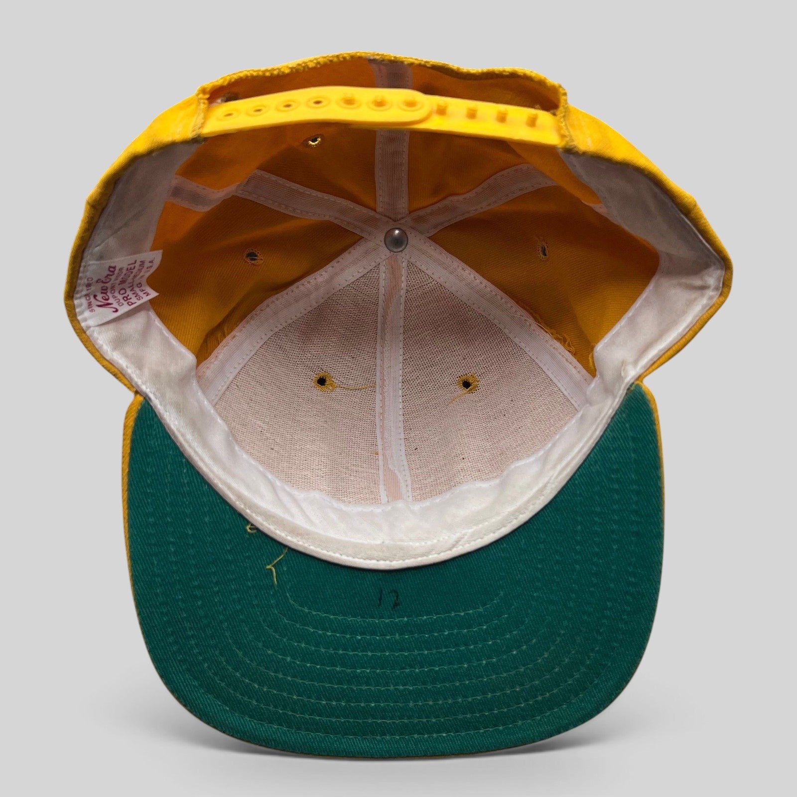 Raree Finds vintage New Era Pro Model snapback hat interior showing gold crown, green visor, and USA made tag.