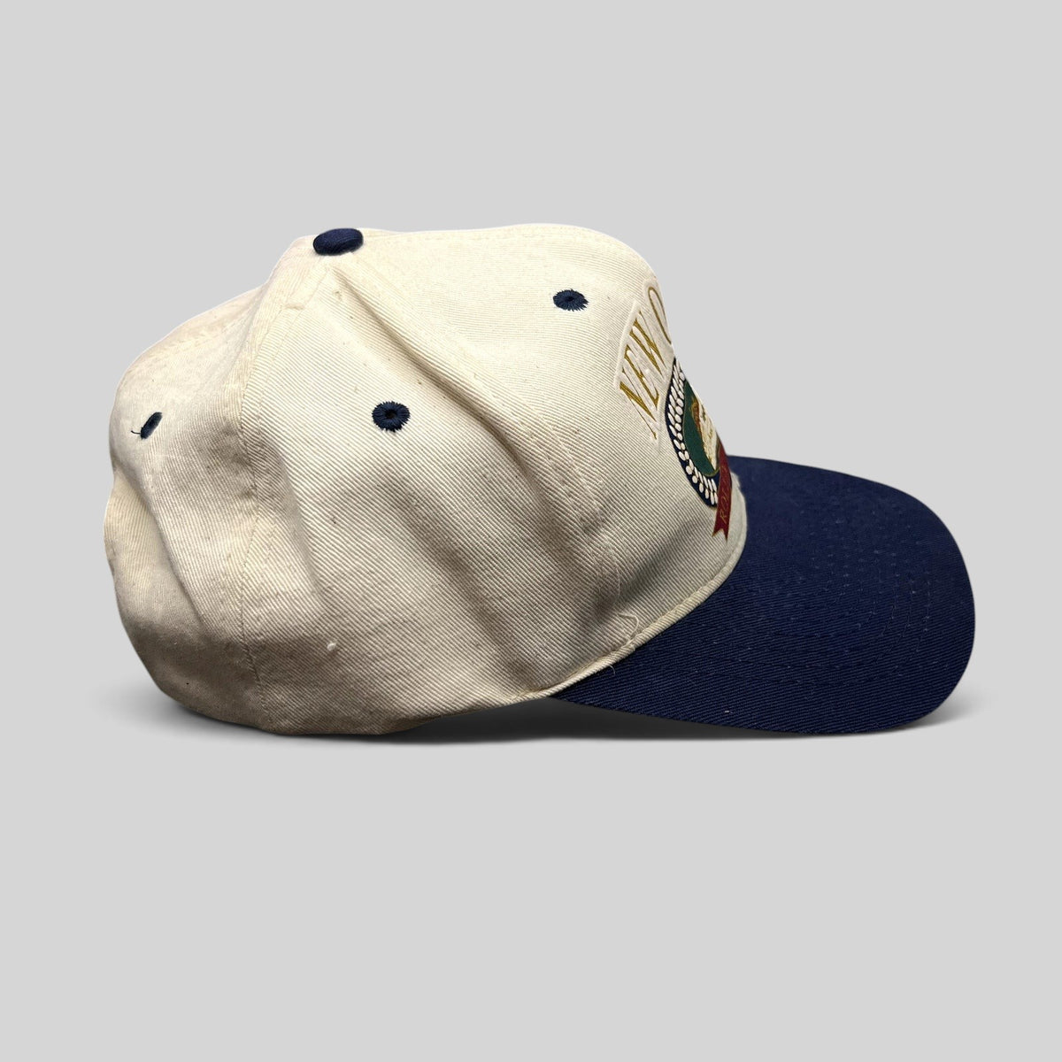 Raree Finds vintage New Orleans snapback hat with cream crown, navy brim, and embroidered riverboat design.