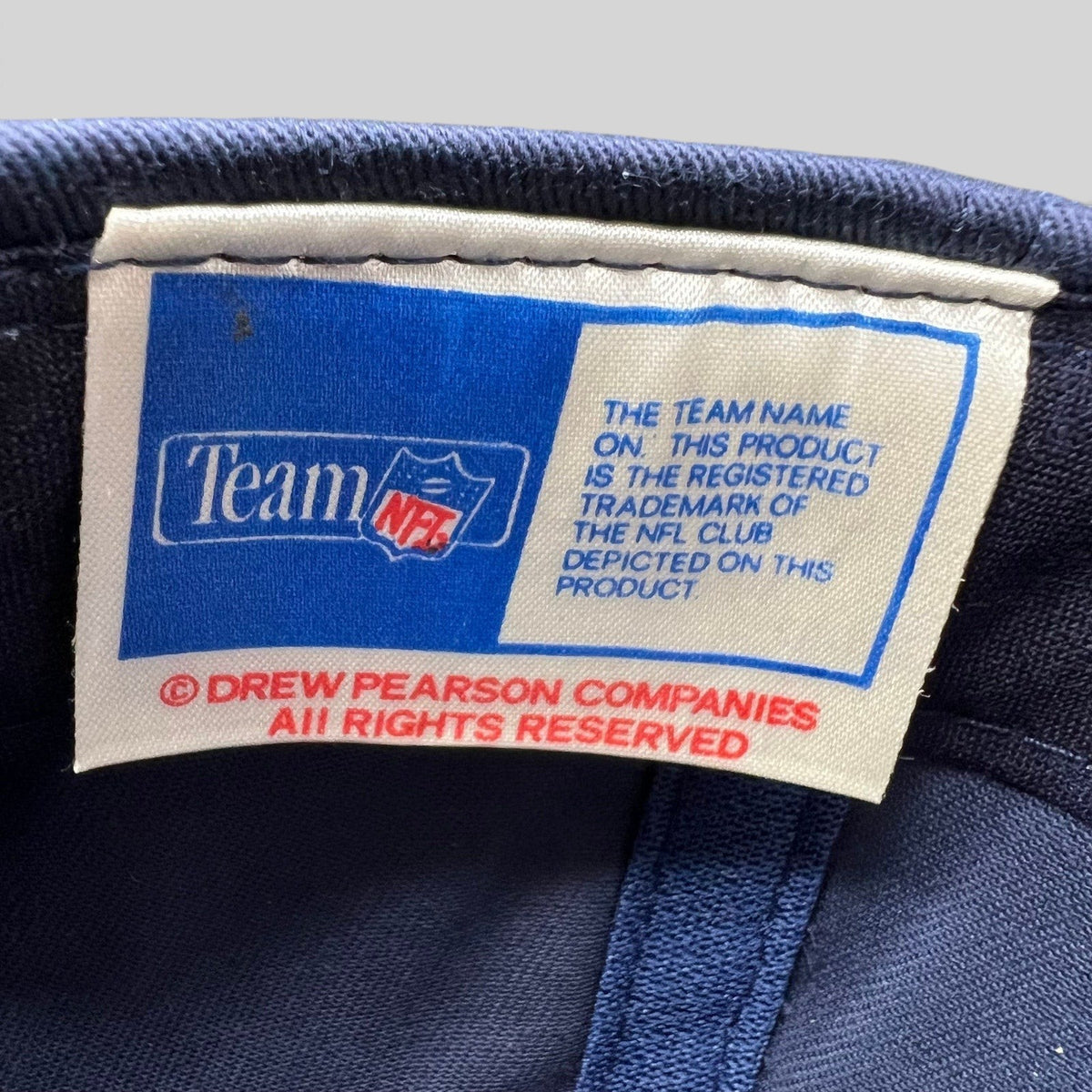 Raree Finds vintage Team NFL Drew Pearson Companies interior hat label with blue and white branding