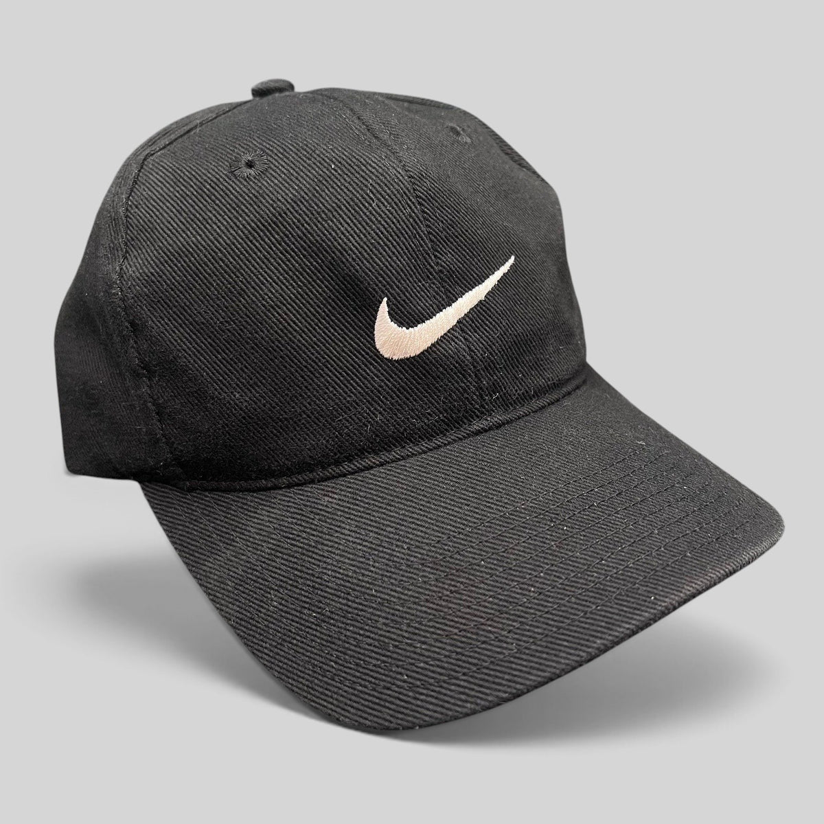 Raree Finds vintage 90s black Nike cotton snapback cap with an embroidered white Swoosh logo on the front panel
